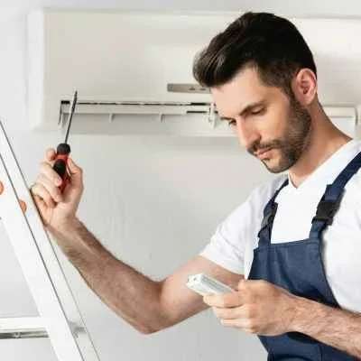 handsome-repairman-holding-remote-controller-and-screwdriver-while-standing-on-stepladder-near-air-qnk8vgg2fnafr5x6dqposcajyv6ch9fgnr74vw3n34_11zon